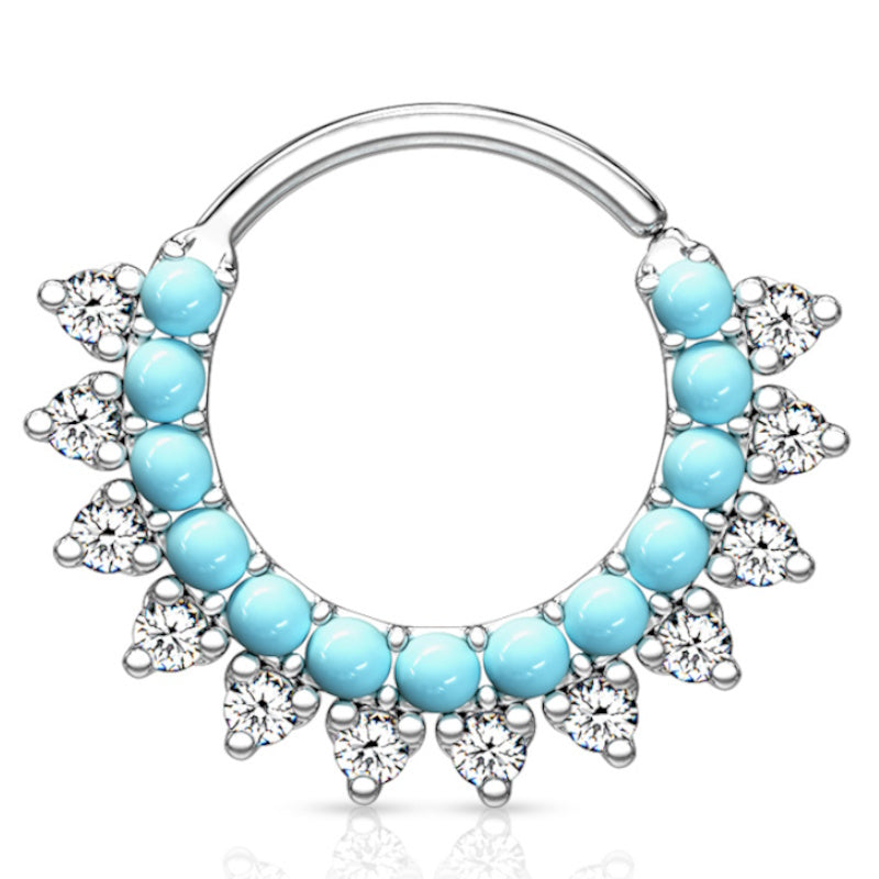 A platinum turquoise septum ring featuring multiple turquoise stones and cubic zirconia lined around the bottom of the bendable hoop pictured against a white background.