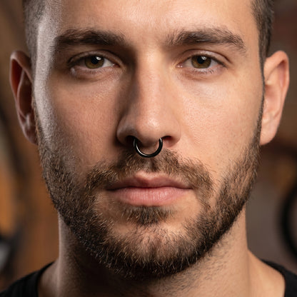 Black Hinged Segment Septum Hoop ASTM F136 Titanium pictured in the septum piercing of a male model.