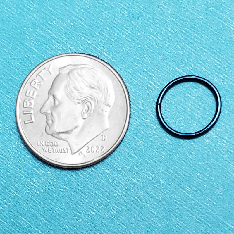 A blue 20g septum ring pictured on an aqua background next to a dime for a size comparison.