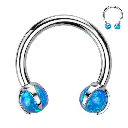 A horseshoe shaped blue opal septum ring with internal threading pictured against a white background.