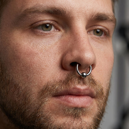 Captive Bead Septum Ring ASTM F136 Implant Grade Titanium in the septum piercing of a male model.
