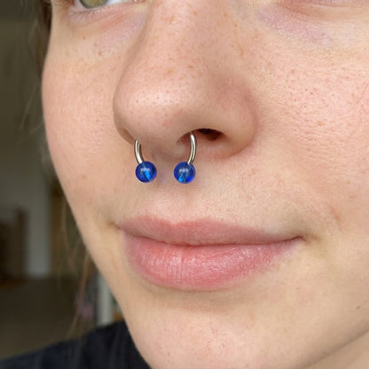 Blue Color Ball Horseshoe Septum Ring 16 Gauge 316L Surgical Steel Acrylic in the septum piercing of a female model.
