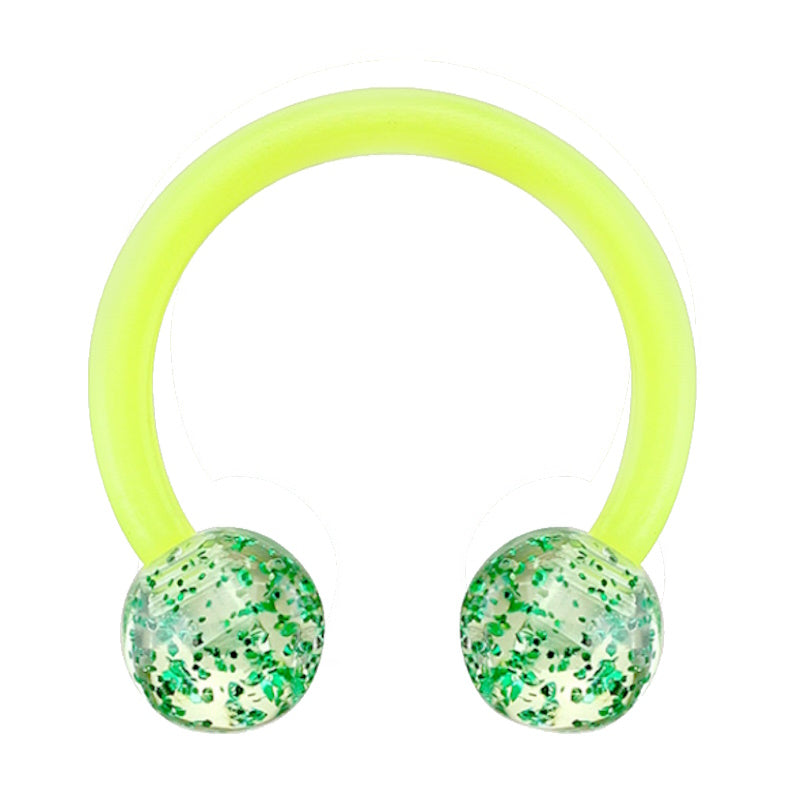 A glitter green septum ring with a horseshoe shaped design and a ball on each end filled with glitter pictured against a white background.