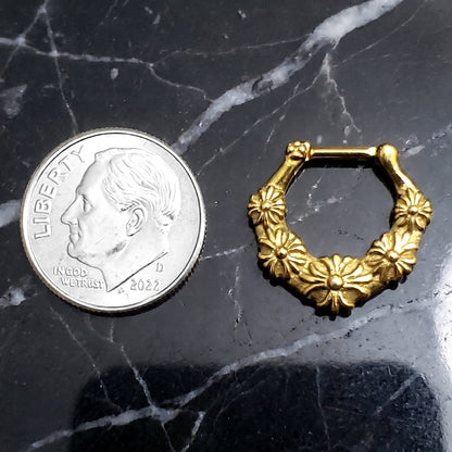 Floral Septum Clicker 16 Gauge Gold Plating Over 316L Surgical Steel pictured on a black marble countertop next to a US dime for size comparison.