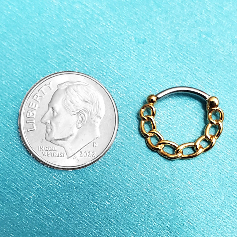 A gold plated chain septum ring pictured on an aqua background next to a dime for size comparison.