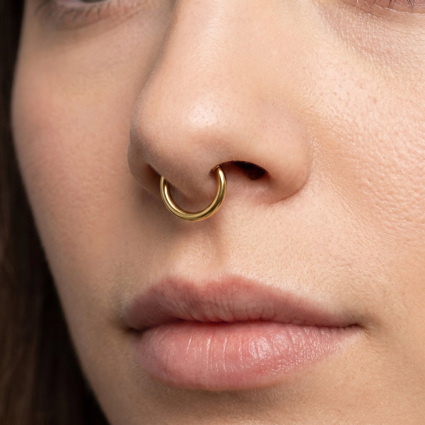 Gold Hinged Segment Septum Hoop ASTM F136 Titanium pictured in the septum piercing of a female model.