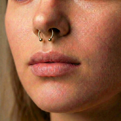 Gold Titanium Septum Ring ASTM F136 Internally Threaded pictured in the septum piercing of a female model.