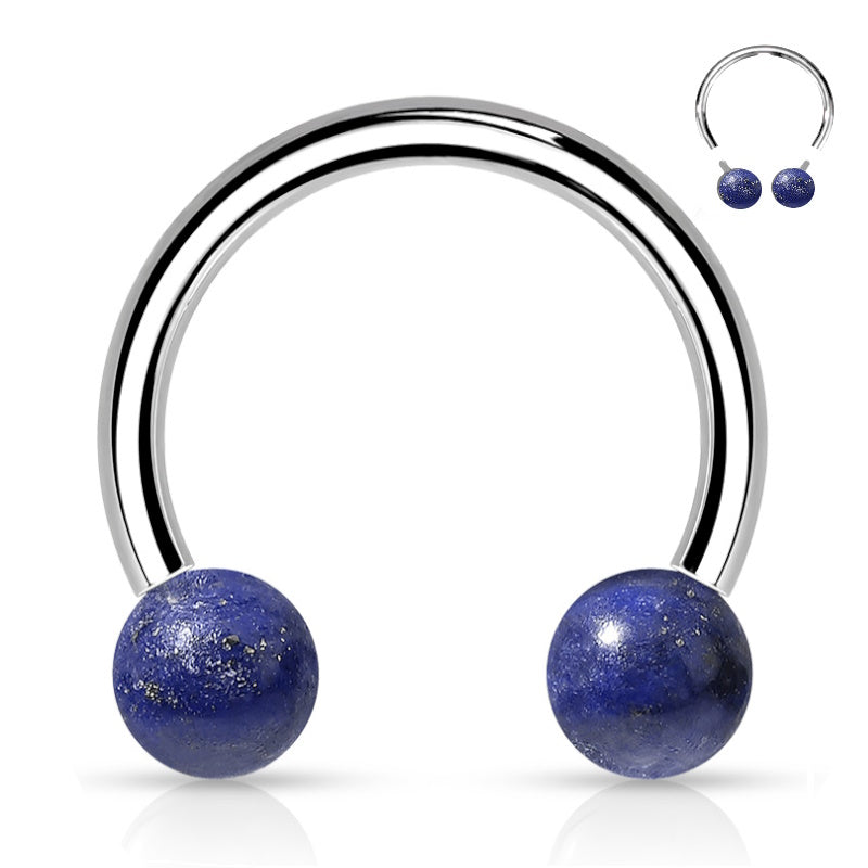 An internally threaded septum ring featuring sodalite blue balls on the ends of the horseshoe ring pictured against a white background.