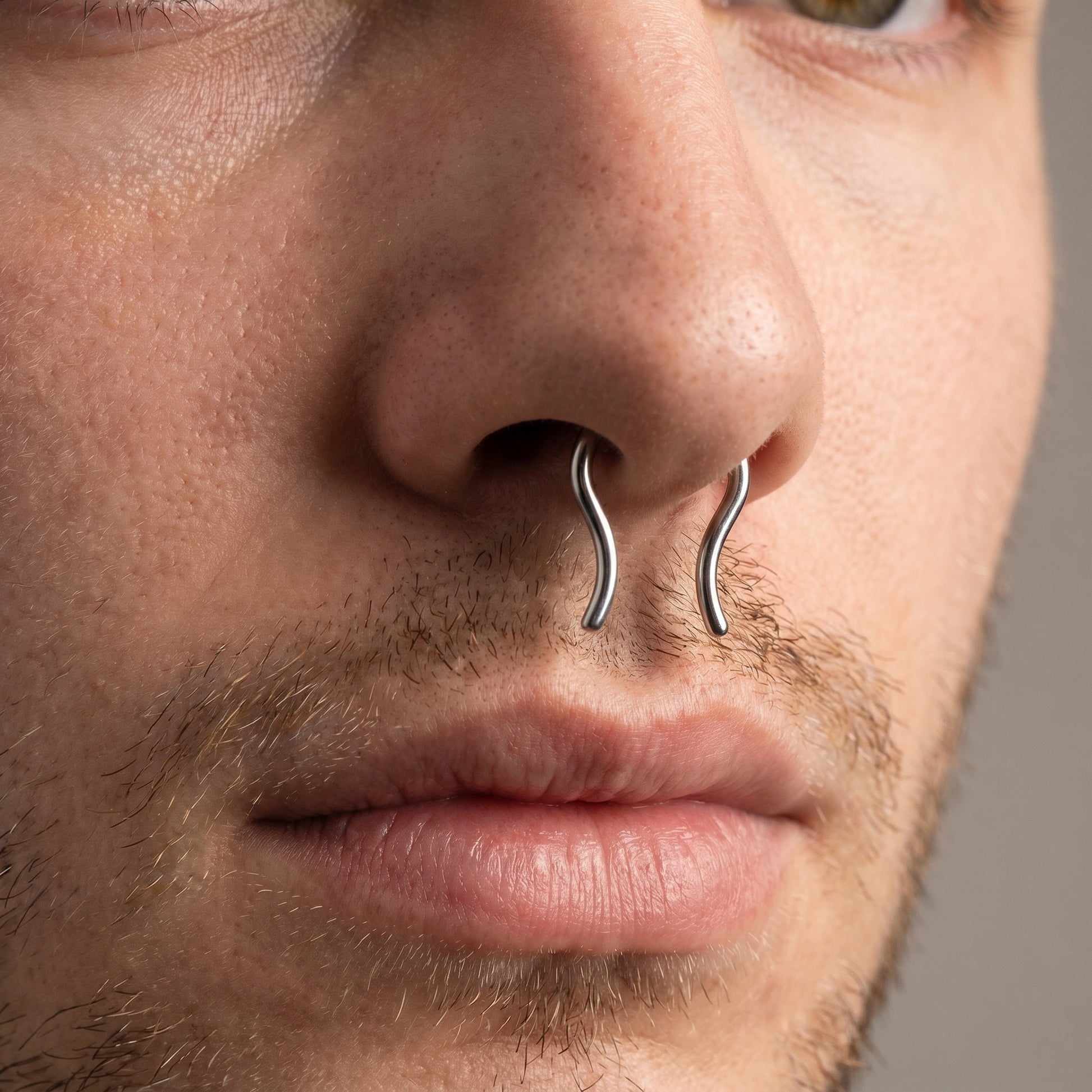 Omega Design Septum Retainer 316L Surgical Steel pictured in the septum piercing of a male model.