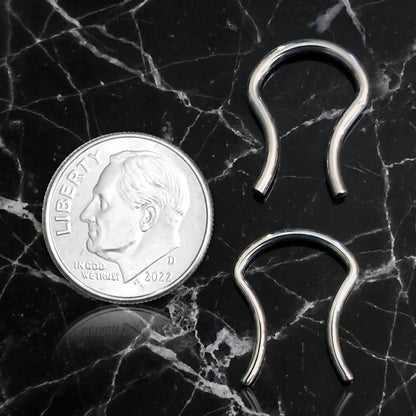 Omega Design Septum Retainer 316L Surgical Steel 16G and 14G pictured next to a US dime for size comparison on a black marble countertop.