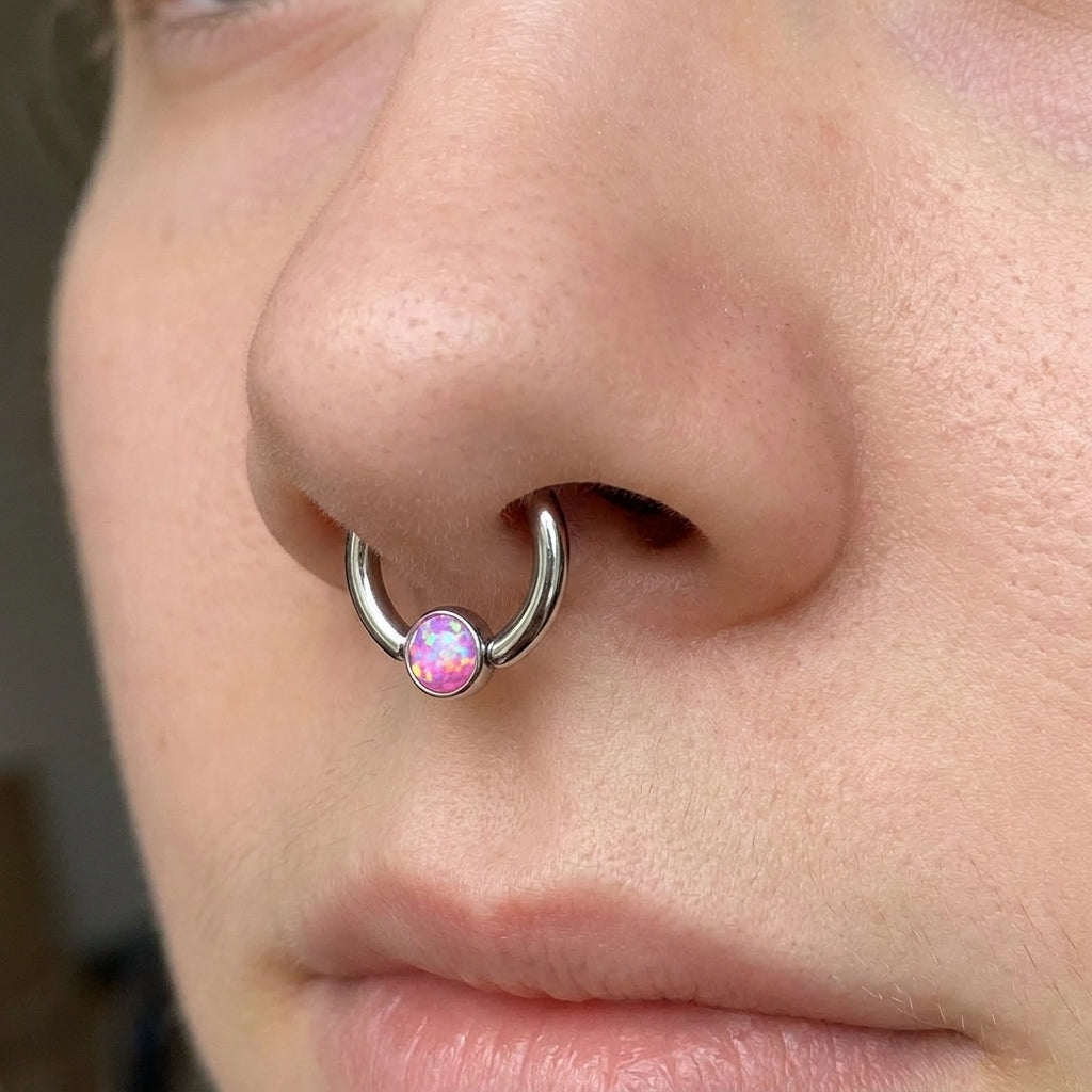 Opal Captive Septum Ring 16 Gauge 316L Surgical Steel 3mm Synthetic Opal in pink pictured in the septum piercing of a female model.