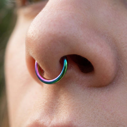 Rainbow Hinged Segment Ring 316L Surgical Steel pictured in the septum piercing of a female model.
