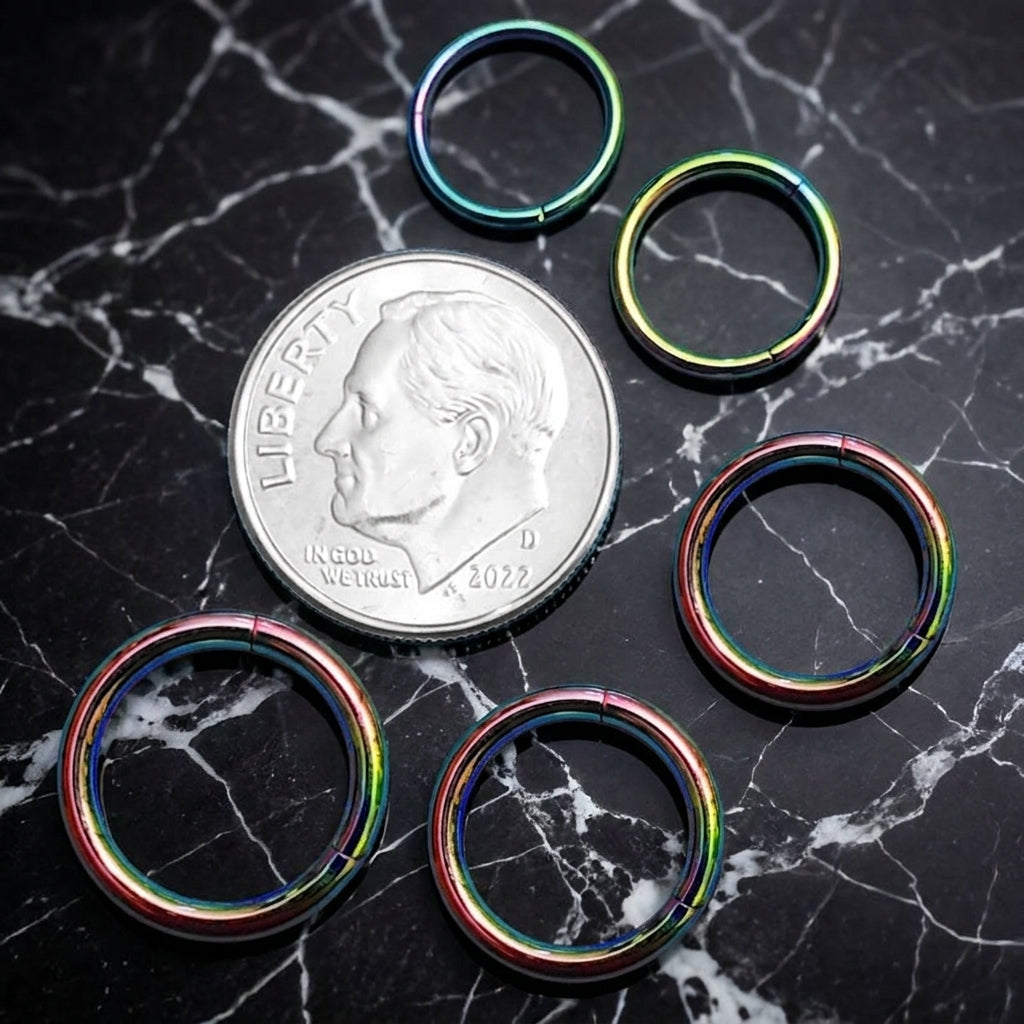 Rainbow Hinged Segment Ring 316L Surgical Steel 20G 18G 16G 14G 12G pictured next to a dime on a black marble countertop for a size comparison.