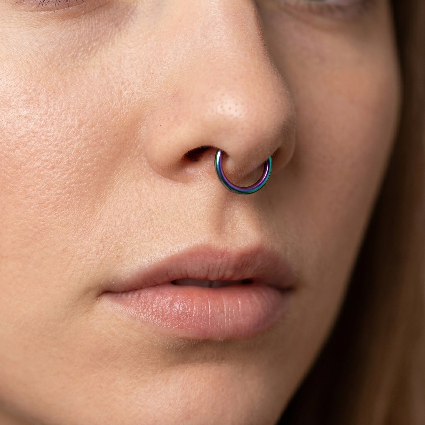 Rainbow Hinged Segment Septum Hoop ASTM F136 Titanium pictured in the septum piercing of a female model.