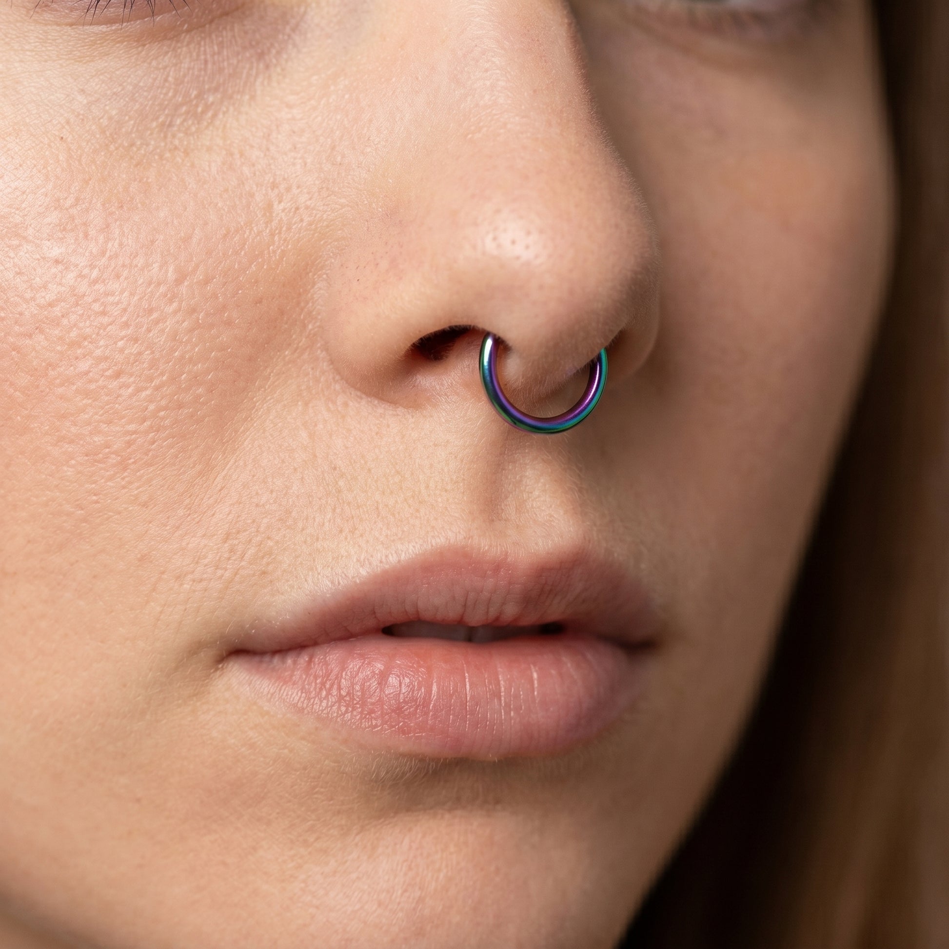 Rainbow Hinged Segment Septum Hoop ASTM F136 Titanium pictured in the septum piercing of a female model.