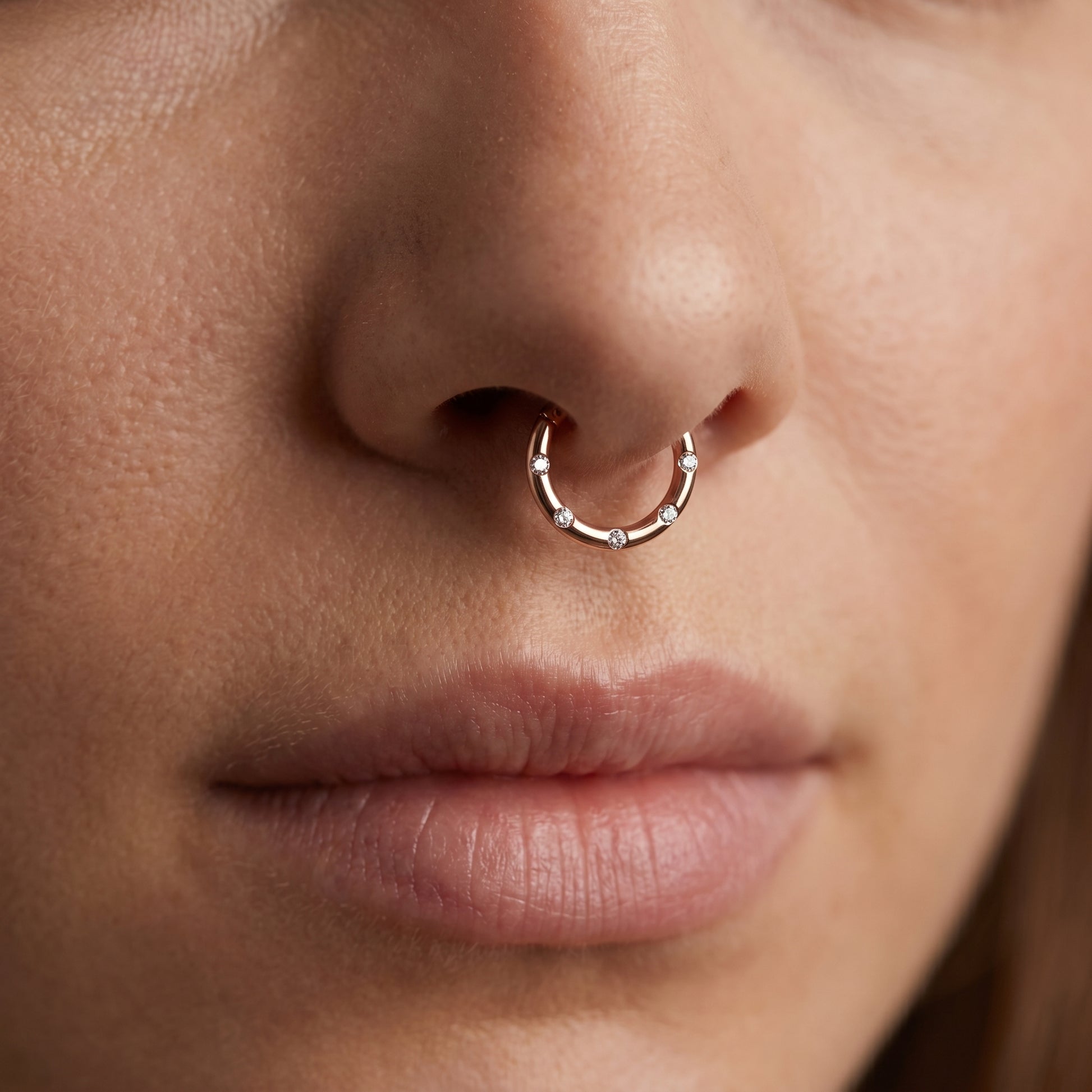 Rose Gold Hinged Segment Ring Cubic Zirconia 16G 316L Surgical Steel pictured in the septum piercing of a female model.