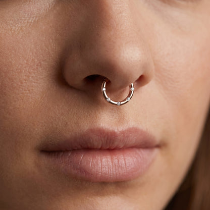 Rose Gold Hinged Segment Ring Cubic Zirconia 16G 316L Surgical Steel pictured in the septum piercing of a female model.