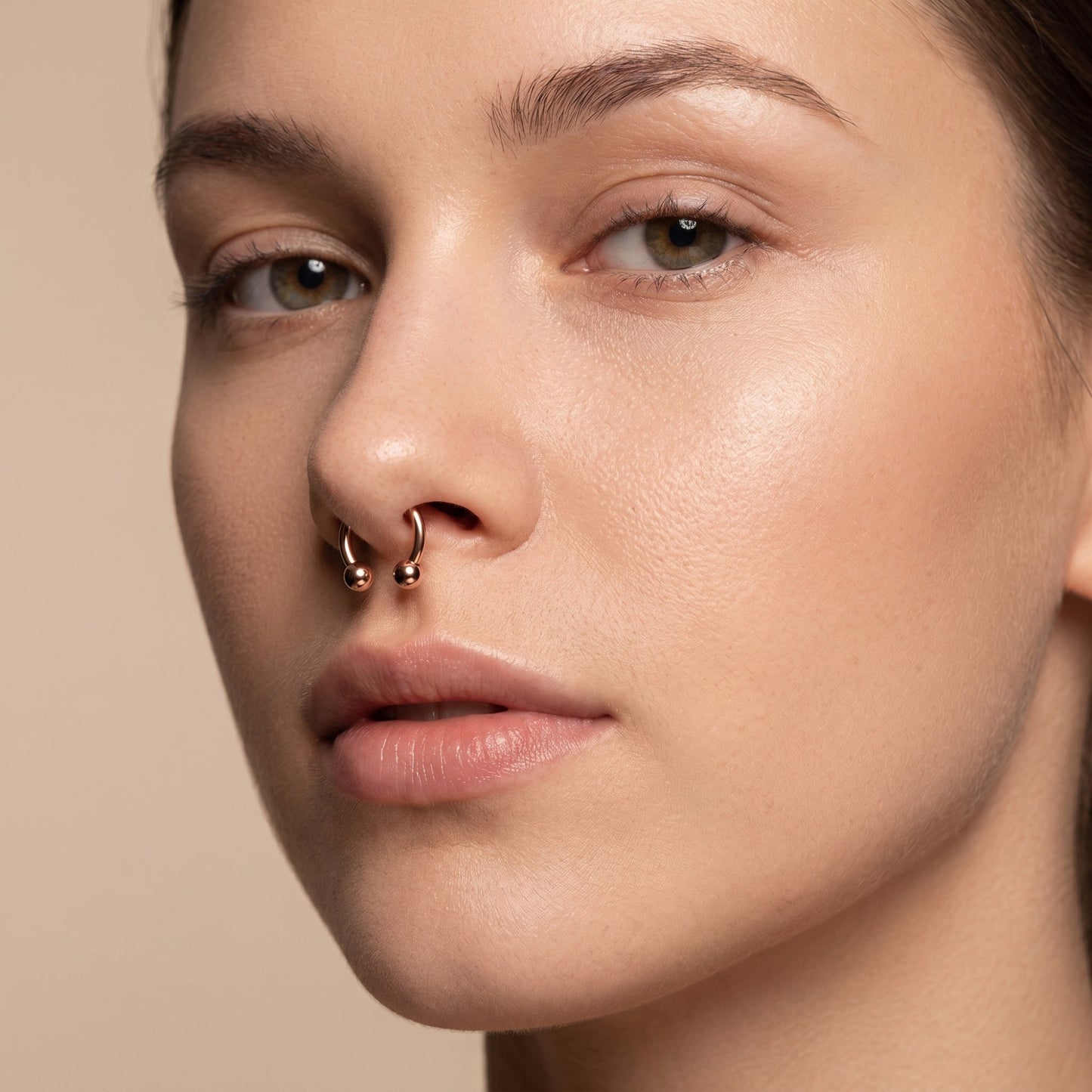 Rose Gold Horseshoe Circular Barbell Septum Ring in the septum piercing of a female model.