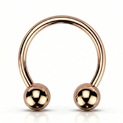 A rose gold horseshoe circular barbell septum ring that is internally threaded with a ball on each end of the horseshoe, pictured against a white background.