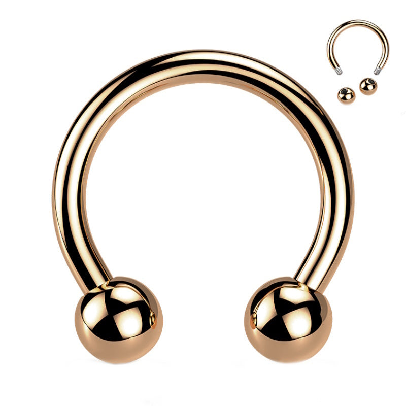 A rose gold horseshoe septum ring that is externally threaded with a ball on each end of the horseshoe pictured against a white background.