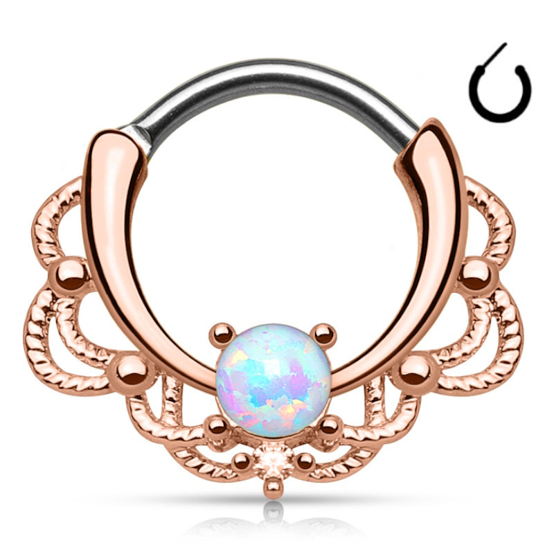 A rose gold septum clicker with a lacy design and an opal in the front and center pictured against a white background.