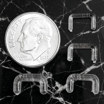 Clear Acrylic Staple Design Septum Retainer 16G 14G 12G 10G pictured next to a dime for size comparison.
