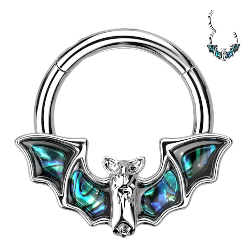 A surgical steel bat septum ring in 16 gauge that features a bat with abalone shell wings and a clicker design closure pictured against a white background.