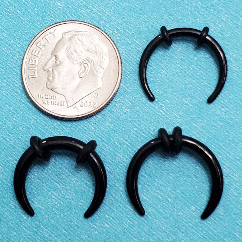 Three sizes of surgical steel black septum pinchers pictured on an aqua background next to a dime for a size comparison.