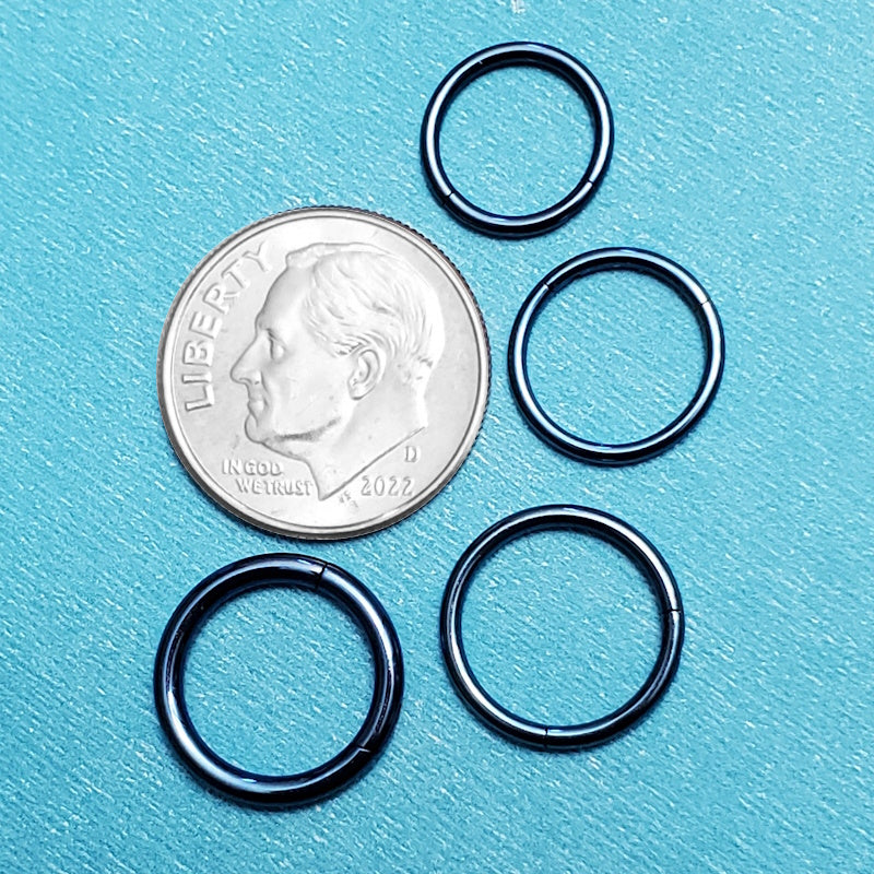 Four sizes of surgical steel blue segment rings pictured on an aqua background next to a dime for a size comparison.