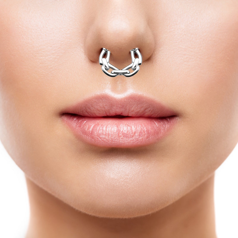 A 16 gauge surgical steel chain septum clicker pictured in the septum piercing of a woman.