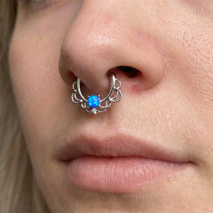 Filigree Blue Opal Septum Clicker 16 Gauge 316L Surgical Steel Brass pictured in the septum piercing of a female model.