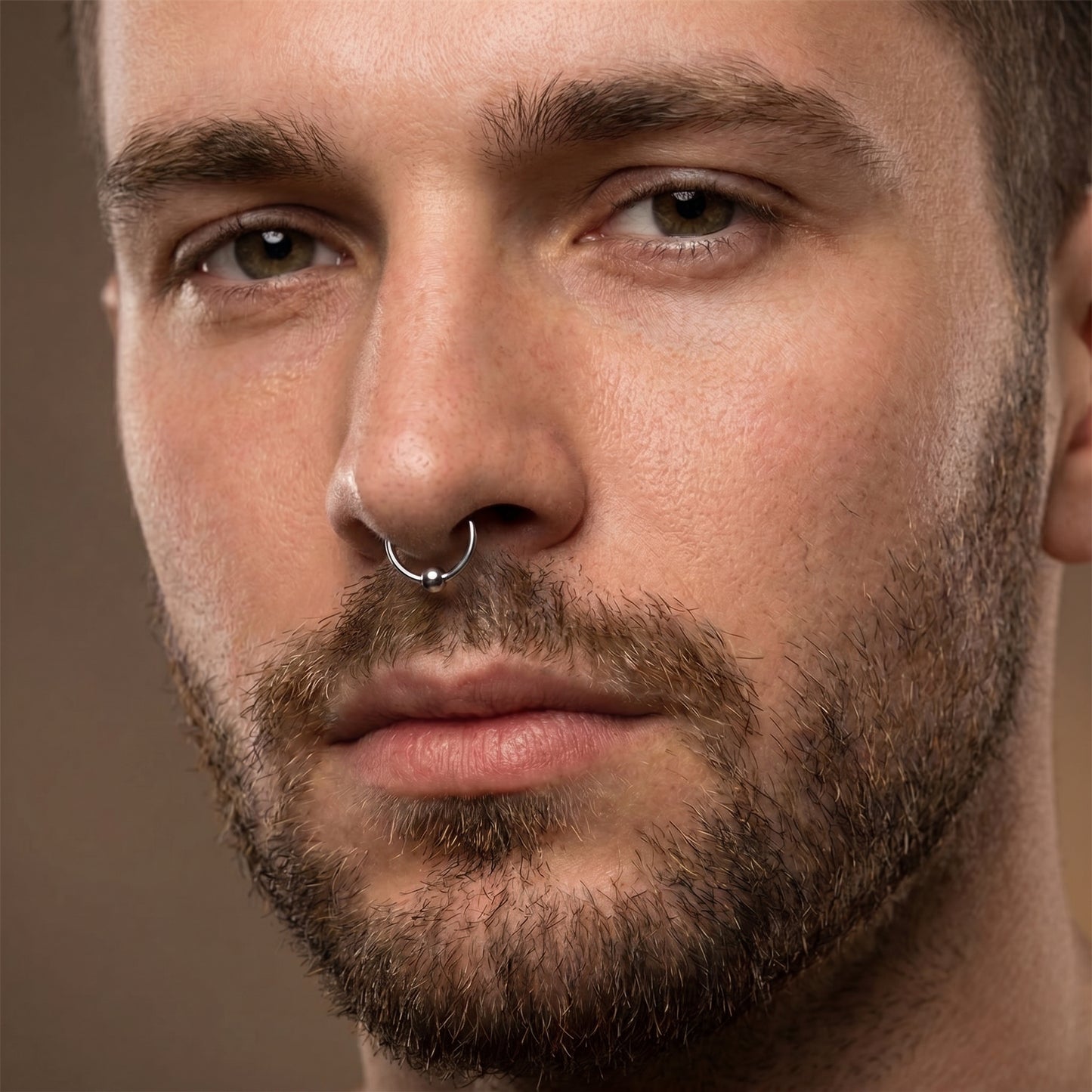 Hinged Segment Fixed Captive Bead Ring 16 Gauge 316L Surgical Steel pictured in the septum piercing of a male model.