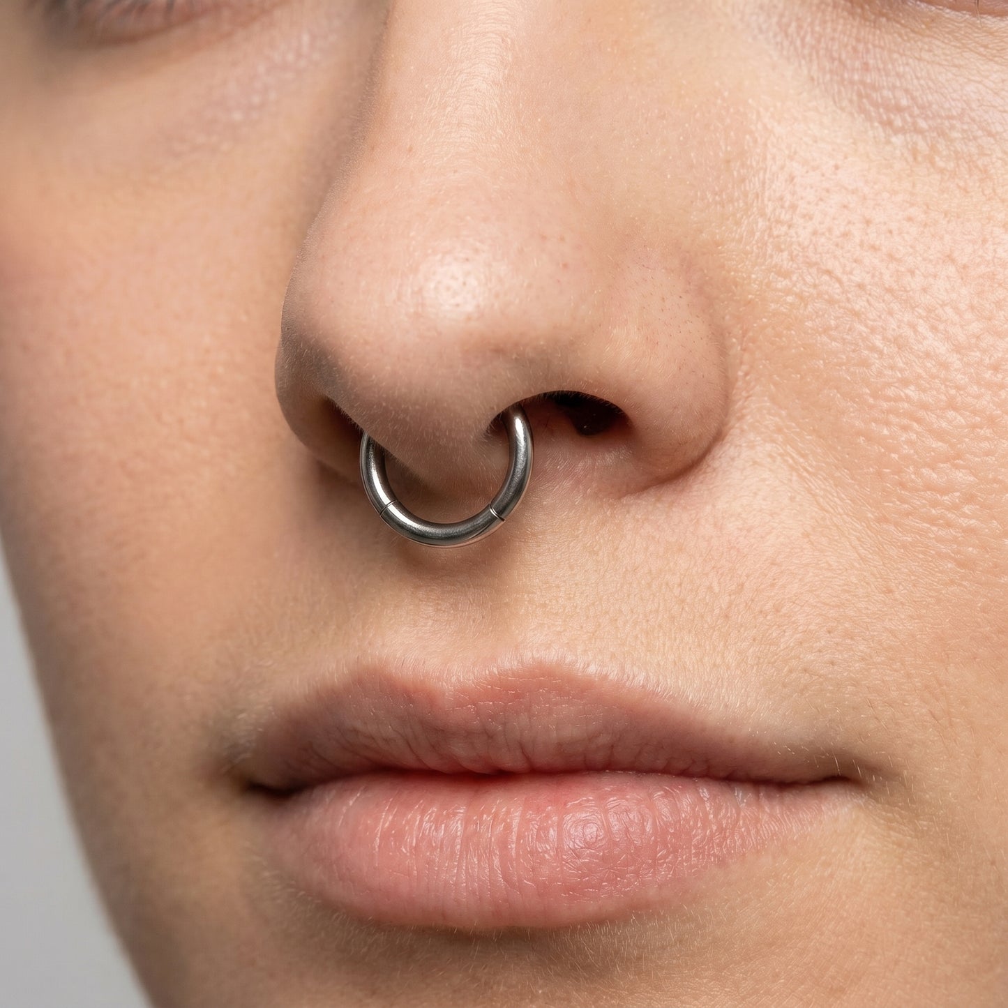 Hinged Segment Septum Ring 316L Surgical Steel pictured in the septum piercing of a female model.
