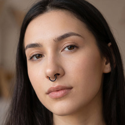 Black Hinged Segment Septum Ring 316L Surgical Steel pictured in the septum piercing of a female model.