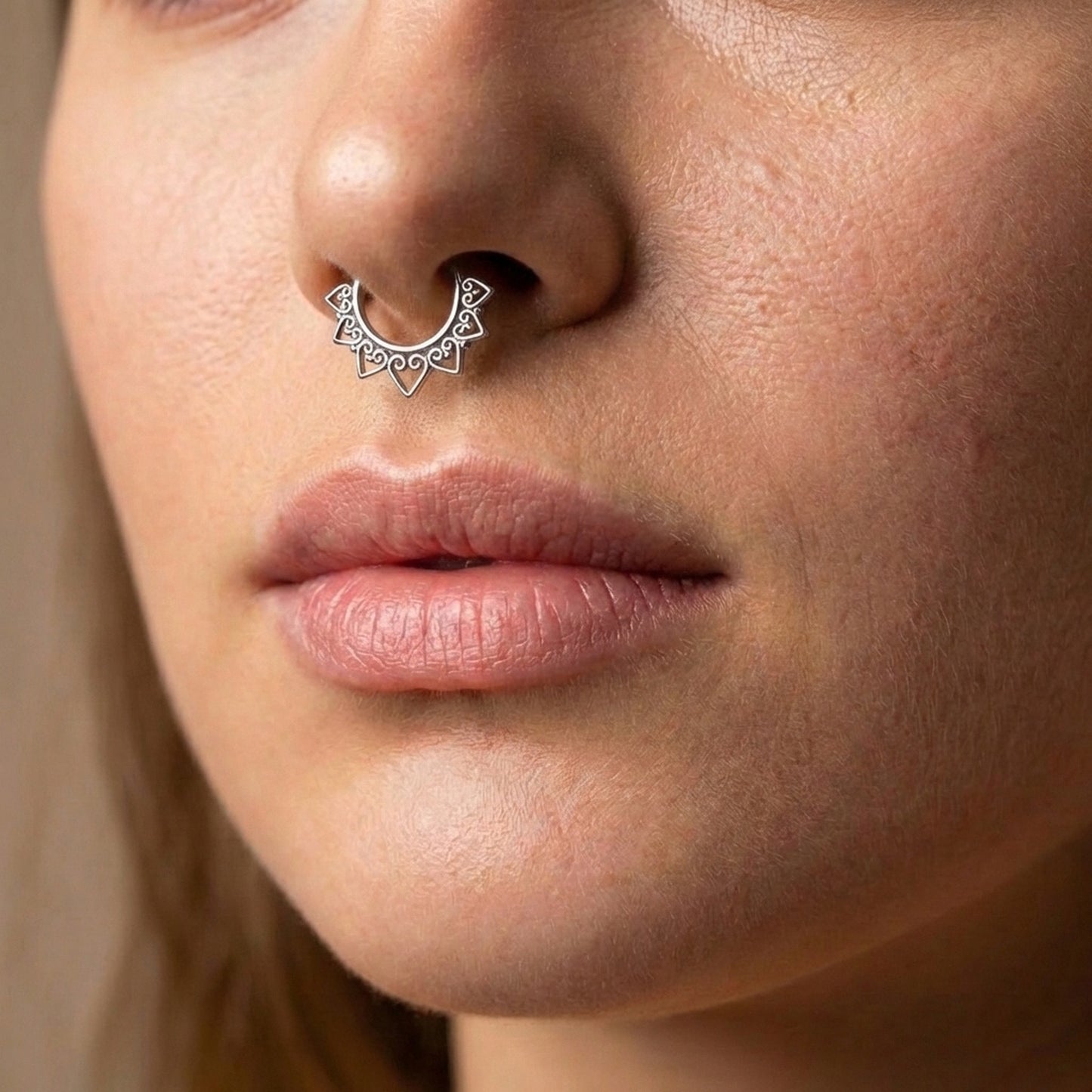 Tribal Septum Clicker Ring 16 Gauge 316L Surgical Steel Silver pictured in the septum piercing of a female model.