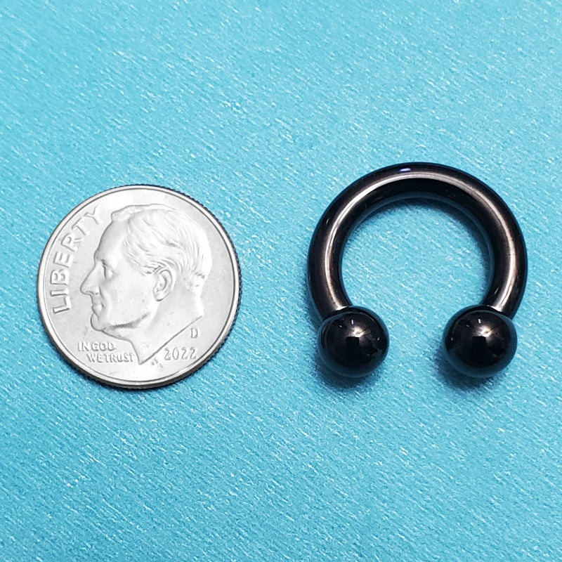 A titanium 8g septum ring pictured on an aqua background next to a dime for a size comparison.