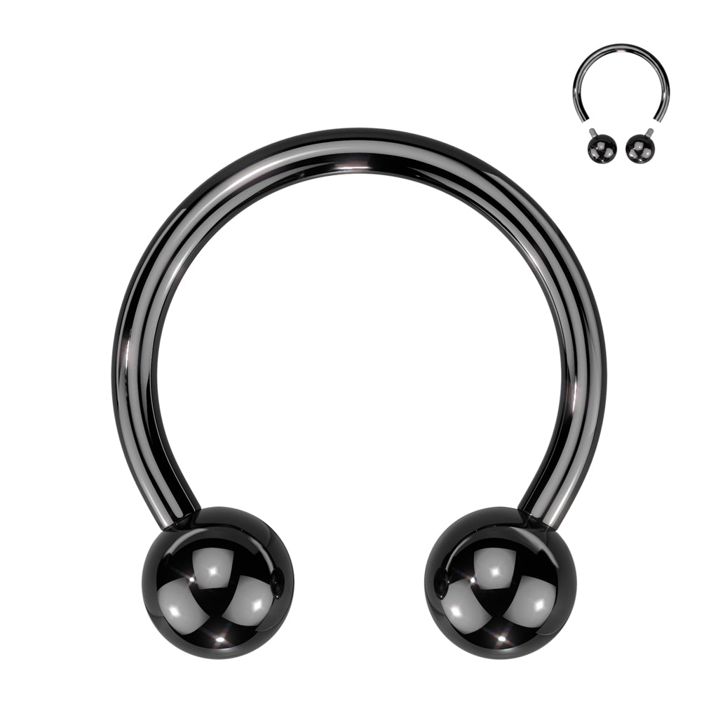 An internally threaded titanium black septum horseshoe with a ball on each end pictured against a white background.