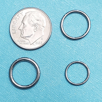 Three sizes of titanium hinged septum rings pictured on an aqua background next to a dime for a size comparison.
