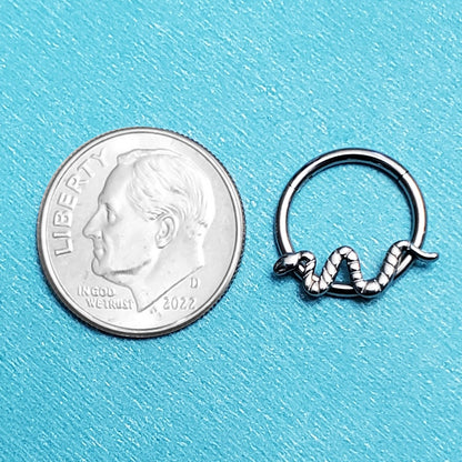 A titanium snake septum ring pictured on an aqua background next to a dime for a size comparison.