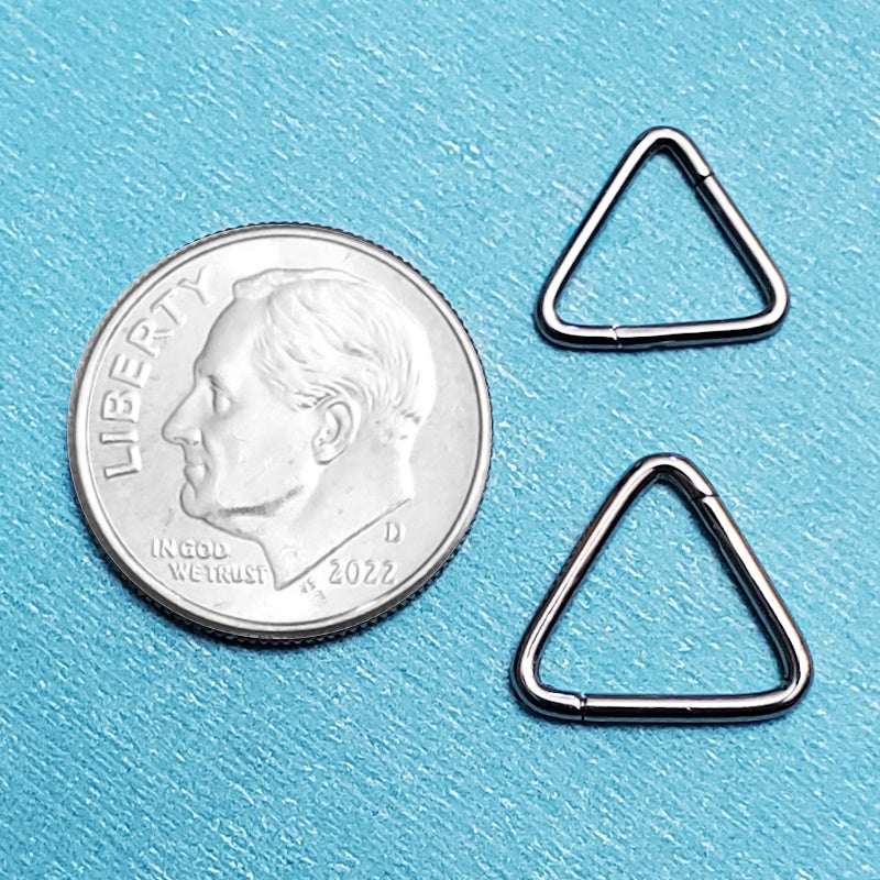 Two sizes of titanium triangle septum rings pictured on an aqua background next to a dime for a size comparison.