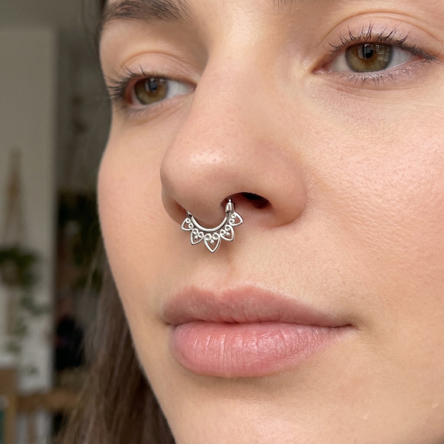 Tribal Fan Septum Clicker 16 Gauge 316L Surgical Steel pictured in the septum piercing of a female model.