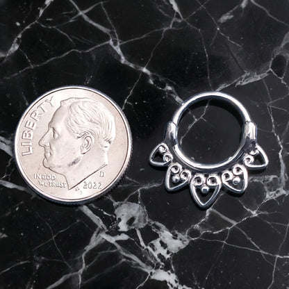 Tribal Fan Septum Clicker 16 Gauge 316L Surgical Steel pictured next to a dime on a black marble countertop to show a size comparison.
